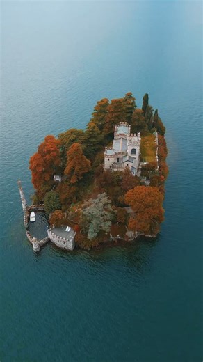 Stay & Wander on Instagram: "Straight out of a fairytale, the tiny, lush Isola di Loreto is Northern Italy's most exquisite hidden gem. The island is dominated by the breathtaking neo-Gothic castle that looks like an oasis fortress from the sea. It's a sheer masterpiece of architecture, with turrets and battlements, built in the early 20th century. The overall scenery, a sun-stone castle amidst a dense grove of pines and alien foliage is the height of Italian romance.⁠ ⁠ Even though you can't st