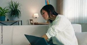 University student using laptop computer for education in campus room. studying indoor sitting on couch. Close-up shot